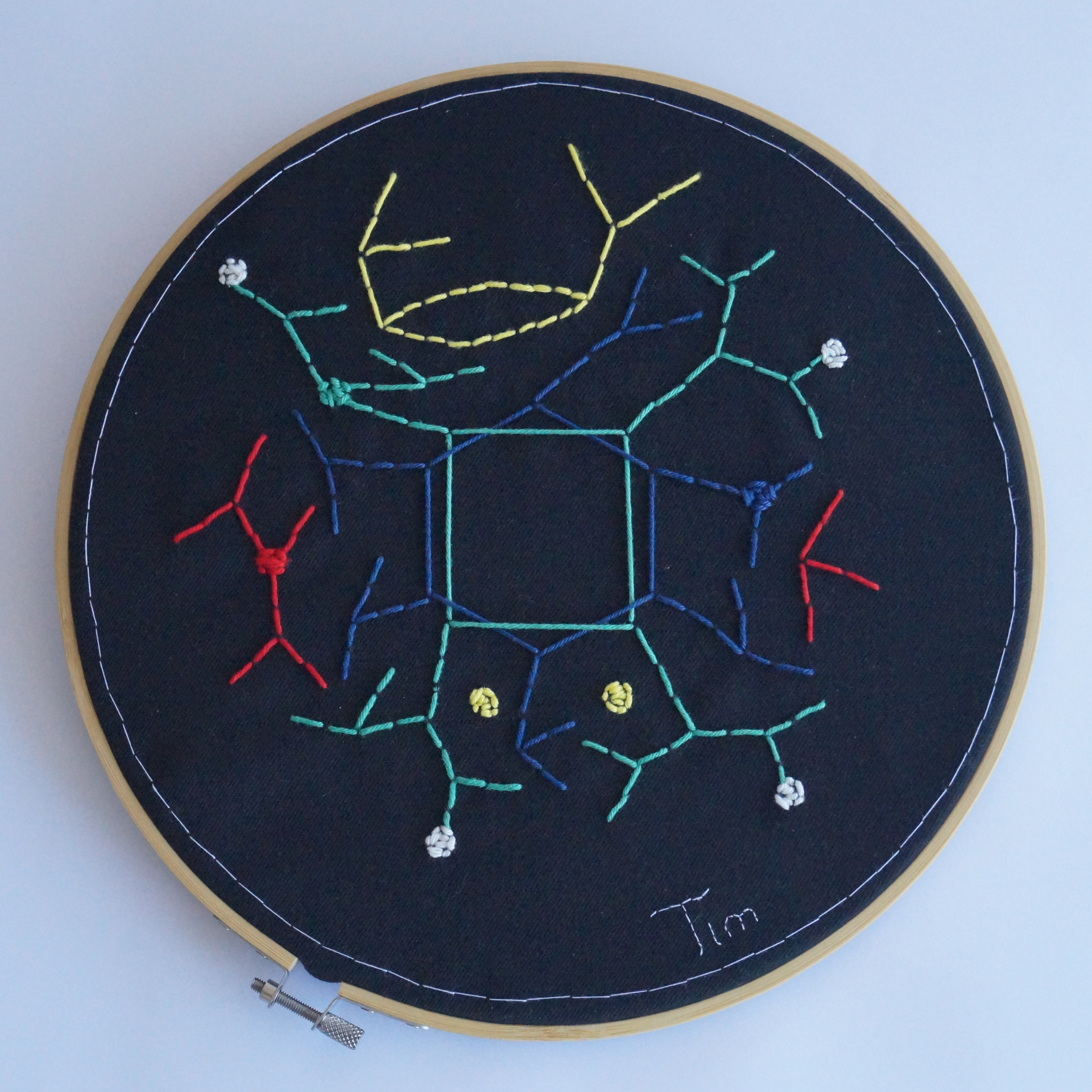 A circular piece of black cloth embroidered with constellation-like structures derived from number theory.