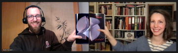 Two Zoom windows next to each other, on the left Martin Skrodzki, on the right Milena Damrau, both smiling into the respective cameras. The each hold up the same page of a book such that the pages aline on the border between their two screens.